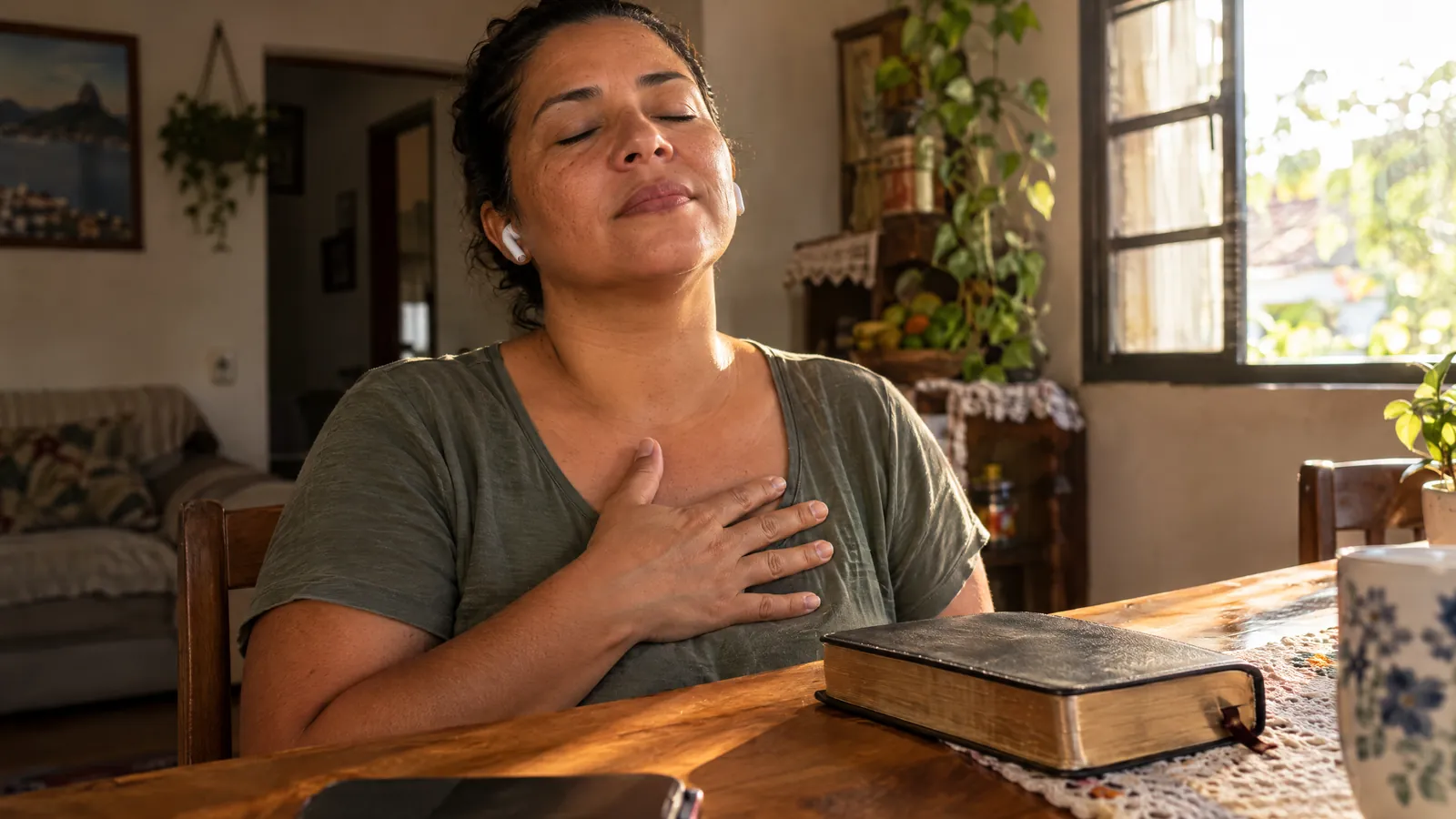 Mulher de olhos fechados ouvindo um louvor personalizado, com a Bíblia ao lado